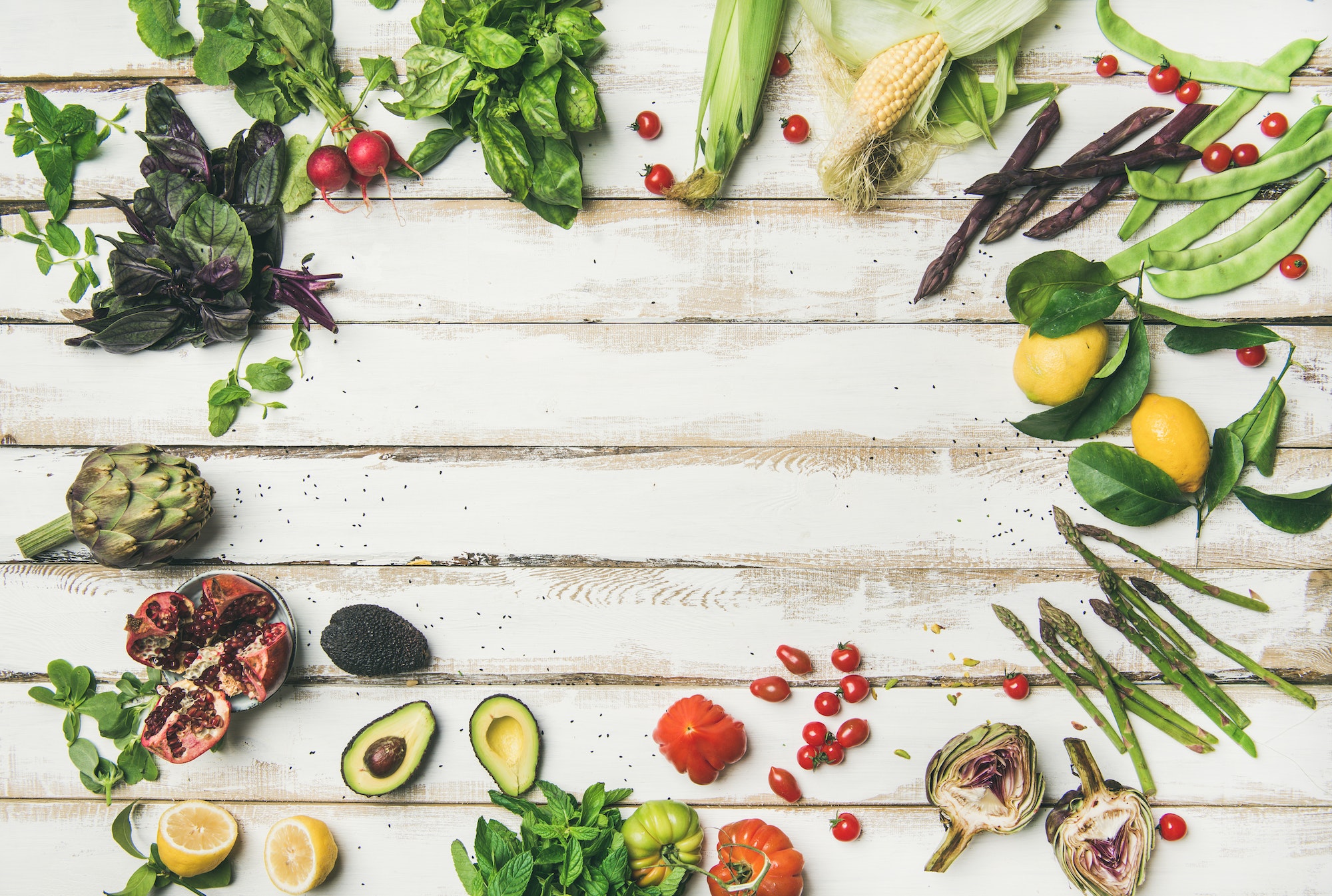 Healthy raw summer vegan ingredients over white wooden background